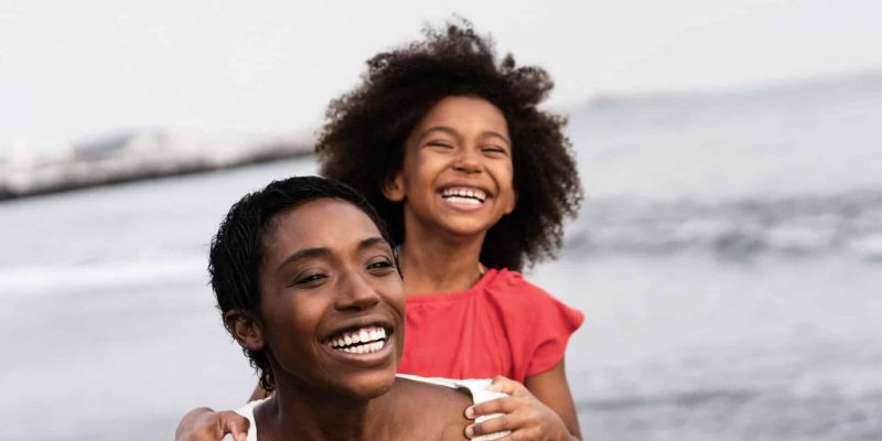 Black,Mother,And,Daughter,Running,On,The,Beach,At,Sunset